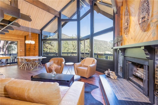 sunroom with a mountain view, vaulted ceiling with beams, wooden ceiling, and a notable chandelier