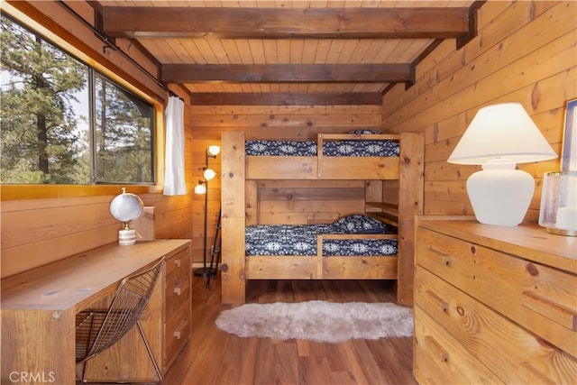 bedroom with beamed ceiling, wooden ceiling, dark wood-type flooring, and wooden walls