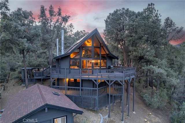 back house at dusk with a deck