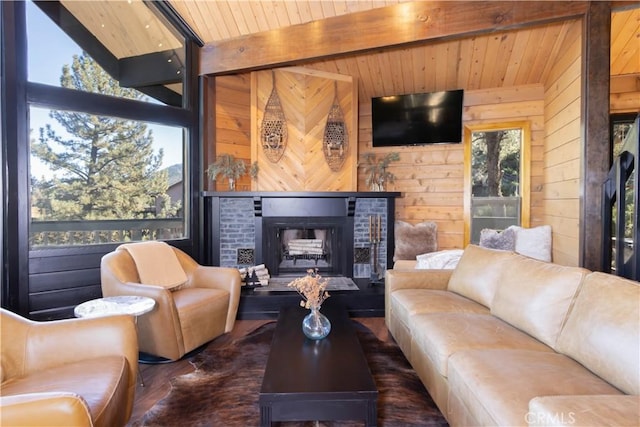 living room with lofted ceiling with beams, wooden ceiling, wooden walls, and a brick fireplace