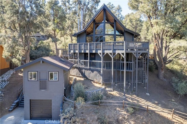 rear view of property with a wooden deck and a garage