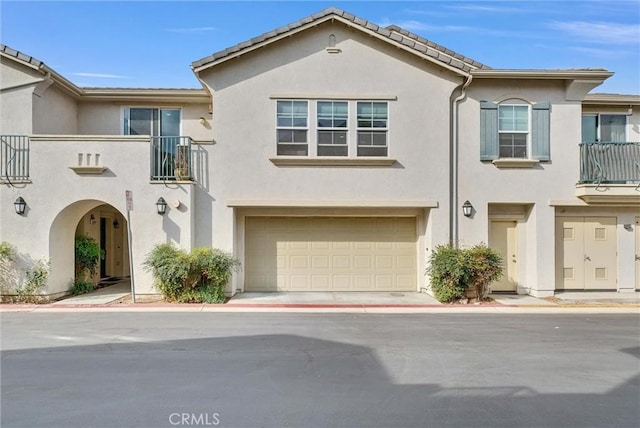 view of front of home featuring a garage and a balcony