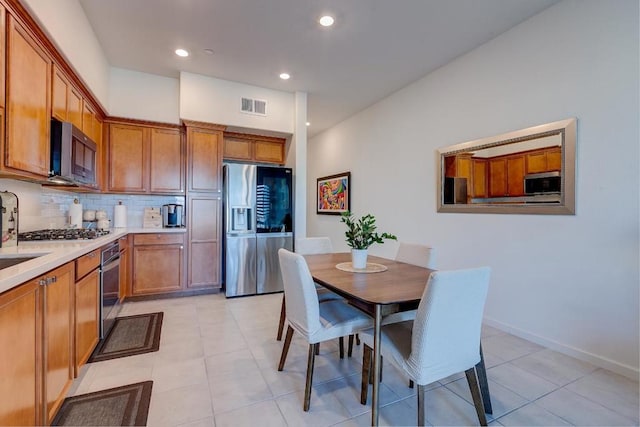 kitchen with light tile patterned floors, backsplash, appliances with stainless steel finishes, and sink