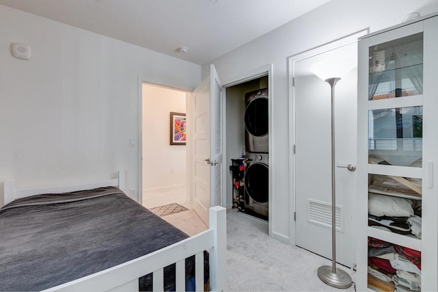 bedroom featuring light colored carpet and stacked washer / dryer