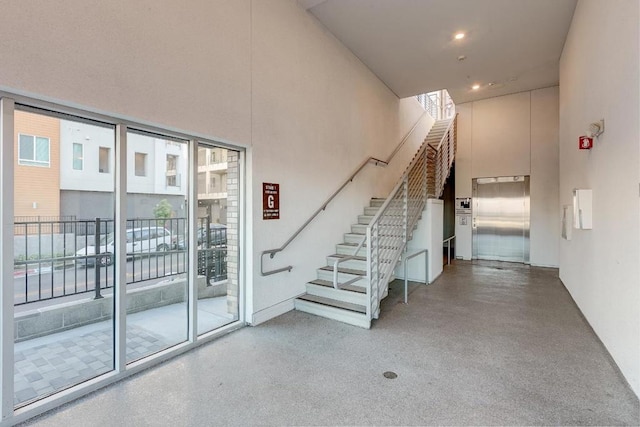 stairway featuring a high ceiling and elevator