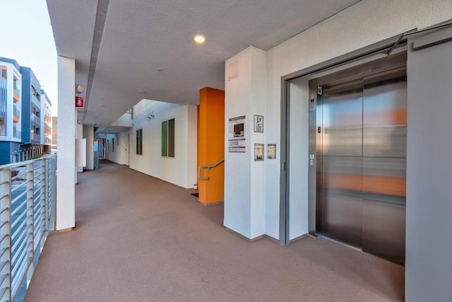 hall featuring elevator and carpet flooring