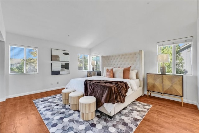 bedroom featuring wood-type flooring, multiple windows, and lofted ceiling