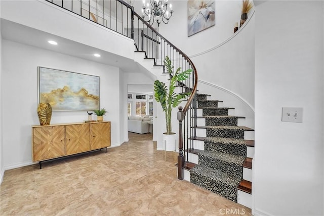 stairs with a notable chandelier and a high ceiling