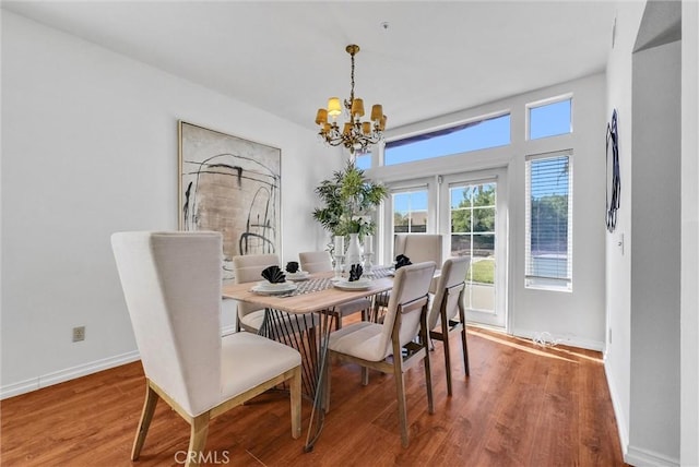 dining area featuring wood-type flooring and an inviting chandelier