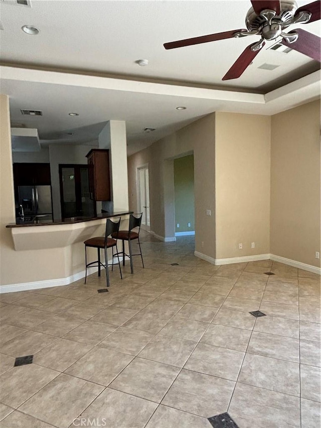 tiled empty room with a tray ceiling