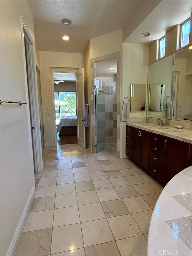 bathroom featuring a shower with shower door, vanity, and tile patterned flooring