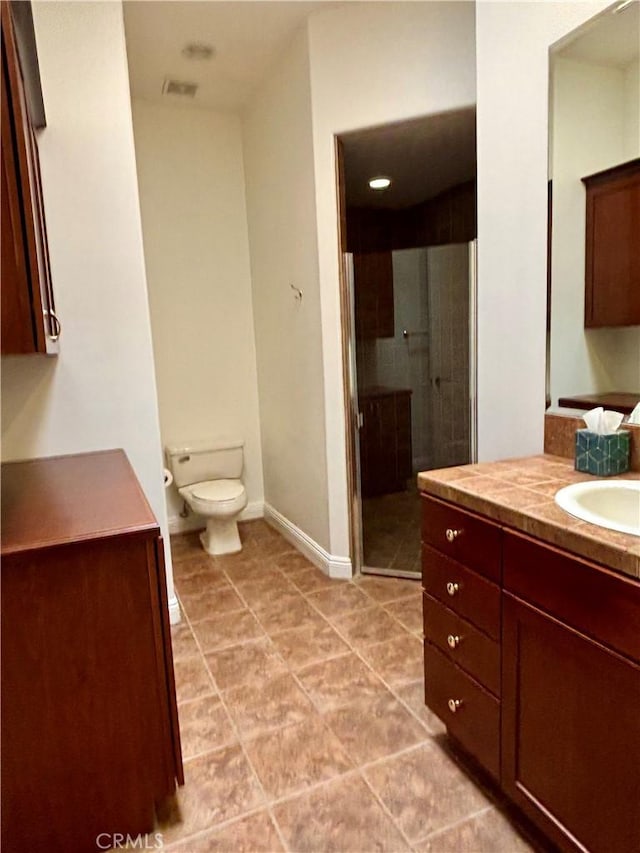 bathroom featuring vanity, toilet, and an enclosed shower