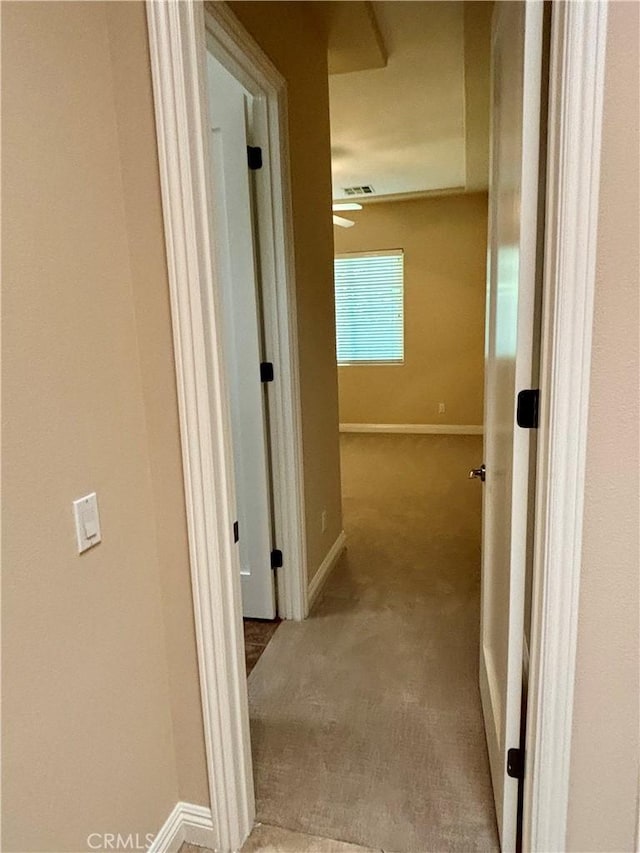 hallway featuring light colored carpet