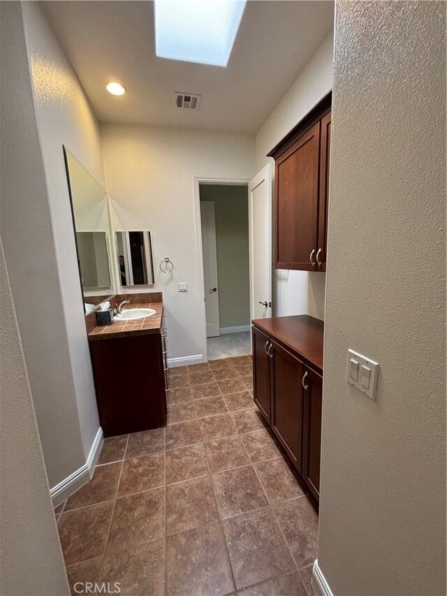 bathroom featuring a skylight and vanity