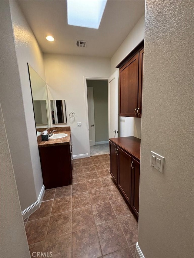 bathroom featuring vanity and a skylight