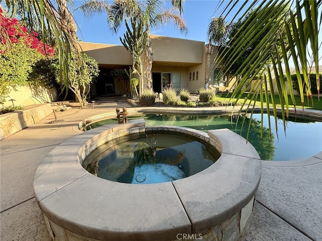 view of swimming pool featuring an in ground hot tub and a patio area