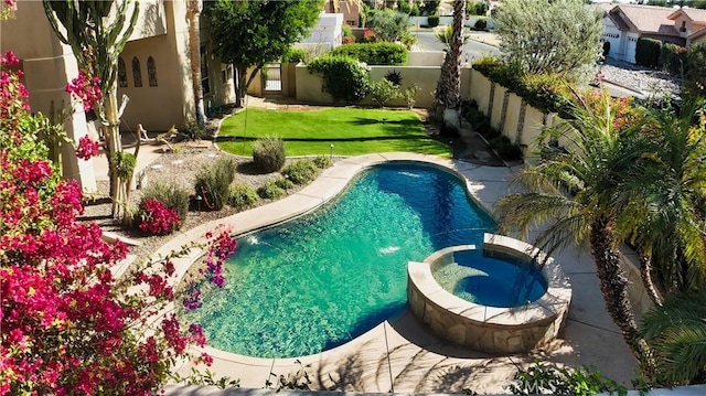 view of swimming pool featuring an in ground hot tub and a yard