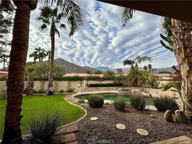 view of yard featuring a mountain view and a swimming pool with hot tub