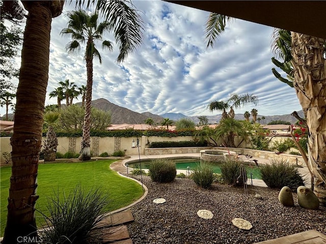 view of yard featuring a mountain view and a pool with hot tub