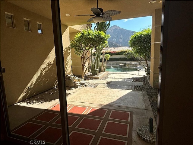 view of patio featuring a mountain view and ceiling fan