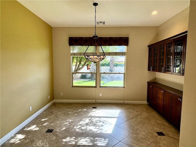 unfurnished dining area featuring light tile patterned floors