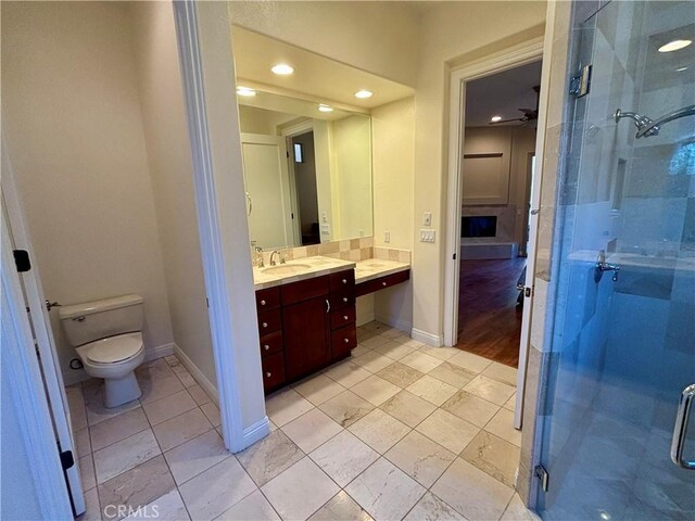 bathroom with tile patterned floors, ceiling fan, toilet, walk in shower, and vanity