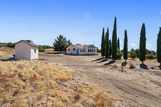 view of yard featuring a rural view and a storage shed