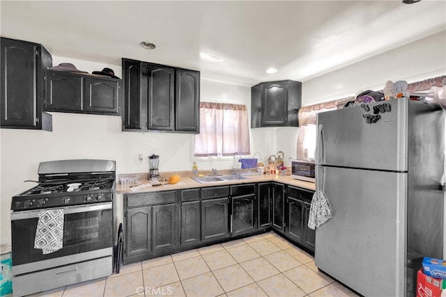 kitchen with sink, appliances with stainless steel finishes, and light tile patterned floors