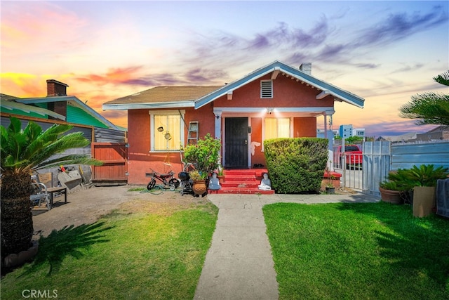 bungalow-style house featuring a lawn