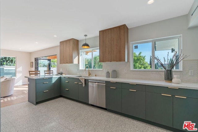 kitchen with tasteful backsplash, stainless steel dishwasher, sink, green cabinets, and hanging light fixtures