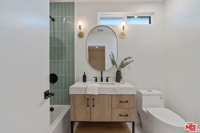 full bathroom featuring toilet, tiled shower / bath combo, and vanity