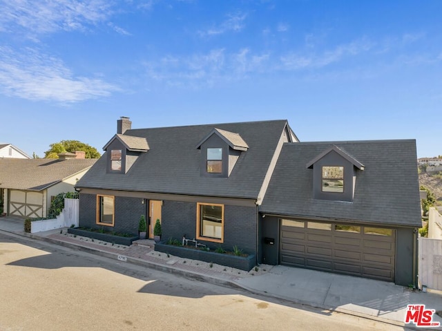 cape cod-style house featuring a garage