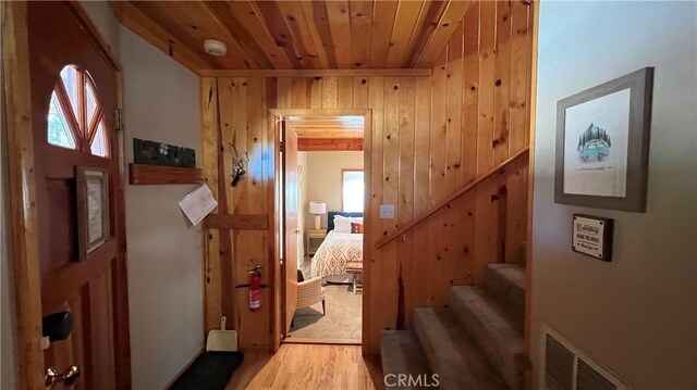 interior space featuring a healthy amount of sunlight, wood ceiling, wooden walls, and hardwood / wood-style flooring