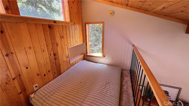 bedroom featuring vaulted ceiling, wooden ceiling, and carpet flooring