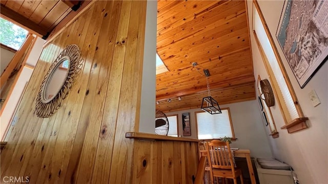 additional living space with beamed ceiling, wood ceiling, wood walls, and high vaulted ceiling