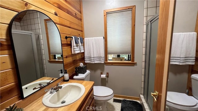 bathroom with toilet, a shower with door, and vanity