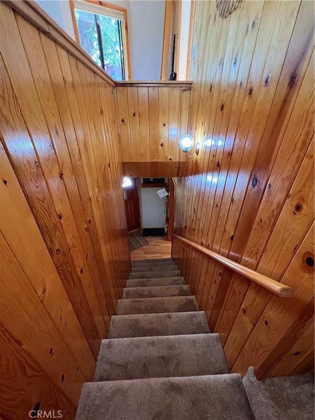 stairs featuring wood ceiling and wood walls