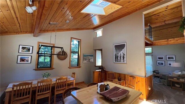 dining area with wooden ceiling, vaulted ceiling with skylight, and carpet