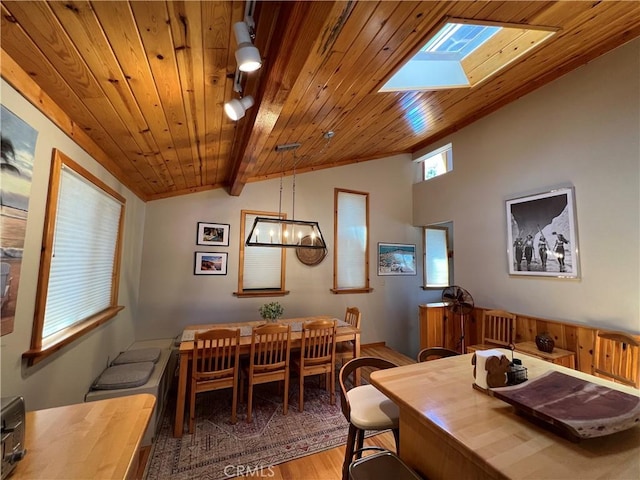 dining space featuring wood ceiling, a notable chandelier, lofted ceiling with skylight, and hardwood / wood-style floors