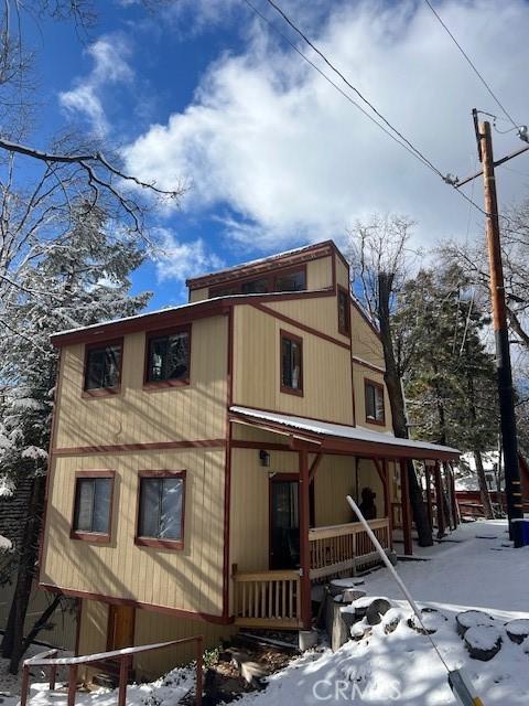 snow covered property featuring a porch