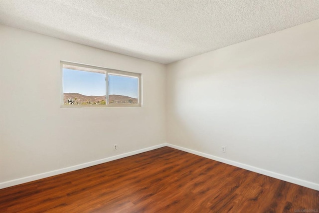 unfurnished room with a textured ceiling and wood-type flooring