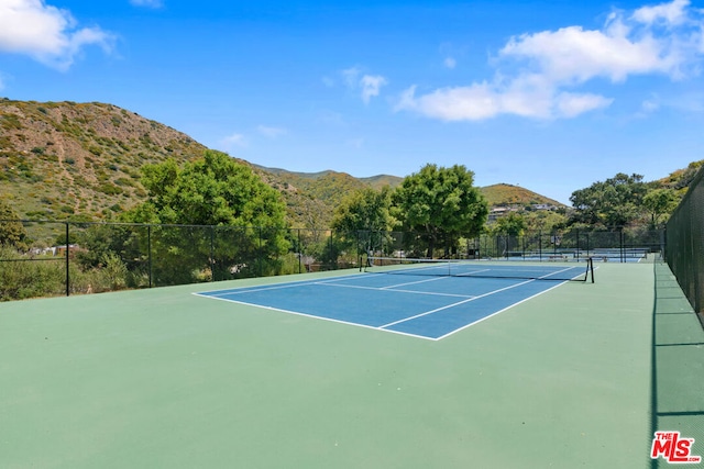 view of sport court featuring a mountain view and basketball hoop