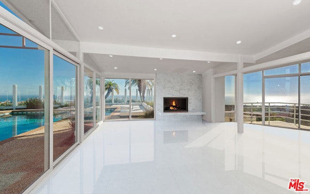 unfurnished living room featuring a premium fireplace and light tile patterned floors