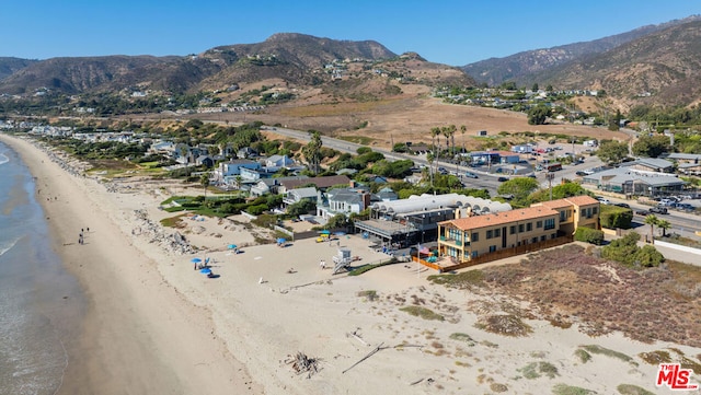 drone / aerial view featuring a mountain view and a beach view