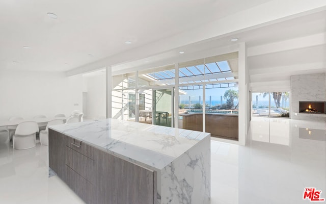 kitchen with a center island, a large fireplace, and light tile patterned floors