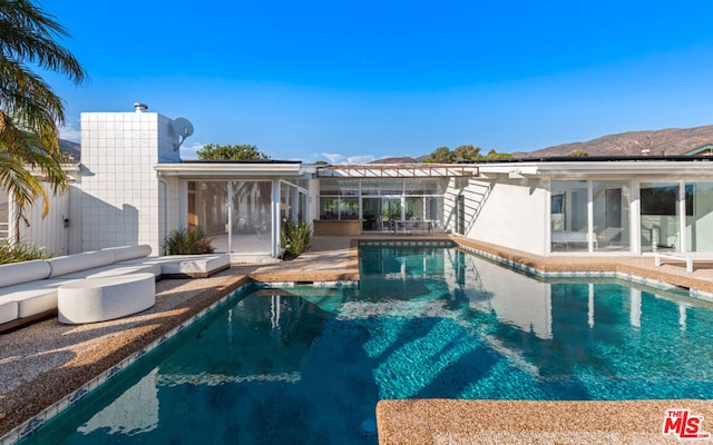 view of swimming pool with a mountain view and a patio