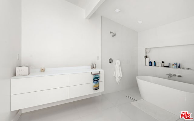 bathroom with tile patterned flooring and a tub to relax in