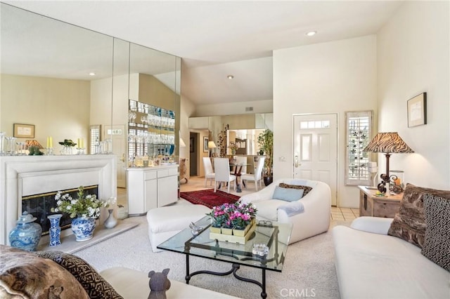 carpeted living room with high vaulted ceiling