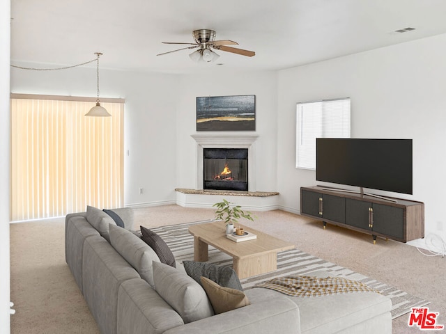 carpeted living room with ceiling fan