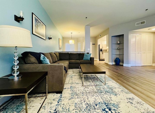 living room with wood-type flooring and built in features